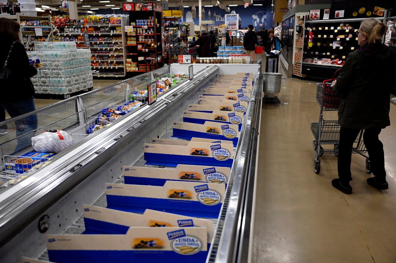 Shoppers walk past empty fresh chicken coolers at ShopRite in Canton on March 13, 2020 in Canton, Connecticut, two days after the World Health Organization characterized the spread of novel Coronavirus a pandemic.